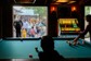 People playing pool next to an outdoor event space with live music and drinks.